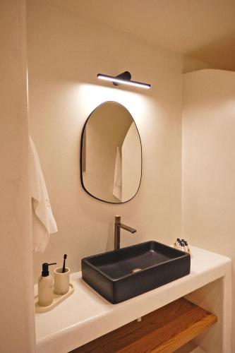 a bathroom with a black sink and a mirror at Agave Donousa Suites in Donoussa
