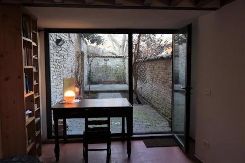 a room with a desk and a door to a courtyard at Casa di Borgo Santo Spirito in Parma