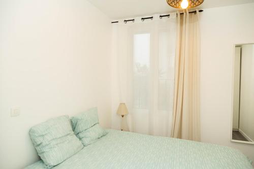 une chambre blanche avec un lit et une fenêtre dans l'établissement Charment studio stade de France 18 pour 4 personnes, à Saint-Denis