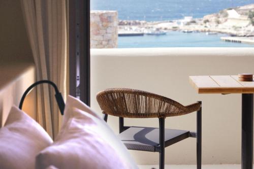 a balcony with a table and a chair and a view at Agave Donousa Suites in Donoussa
