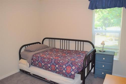 a bedroom with a bed and a nightstand and a window at Rustic Rapids · Wood Stove, Creek, Sauna in Packwood