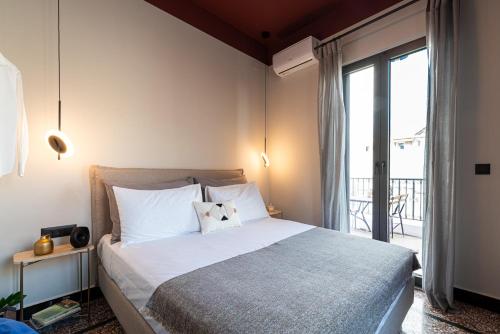 a bedroom with a large bed and a balcony at MOD 15 City Centre in Agios Nikolaos