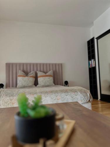 une chambre avec un lit et une table avec une plante dans l'établissement Appartement 12 min Paris - Parking Privé Gratuit - Wifi - Netflix - Balcon, à Enghien-les-Bains