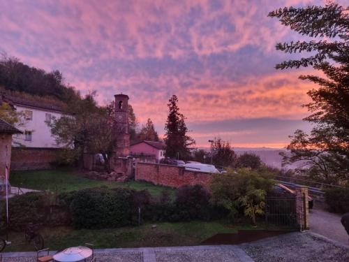 a house on a hill with a sunset in the background at Villa Paradiso in Isola d'Asti