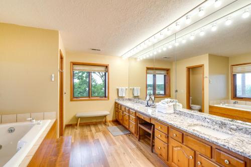 ein großes Bad mit einer Badewanne, einem Waschbecken und einer Badewanne in der Unterkunft Spacious Osage Beach Home with Panoramic Lake Views in Osage Beach