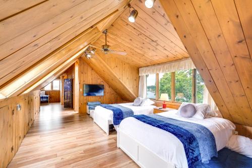 zwei Betten in einem Zimmer mit Holzdecken in der Unterkunft Spacious Osage Beach Home with Panoramic Lake Views in Osage Beach