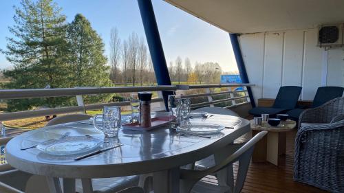 une table avec des assiettes et des verres sur un balcon dans l'établissement L'Hermione, à Dienville