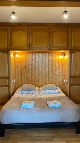 une chambre avec un grand lit avec deux serviettes dessus dans l'établissement L'Hermione, à Dienville