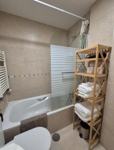 a bathroom with a tub and a toilet and a sink at Las Margas Apartamento in Sabiñánigo