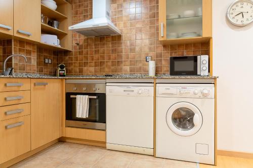 a kitchen with a washing machine and a microwave at Con Vistas a la Montaña, Parking y WiFi in El Tarter