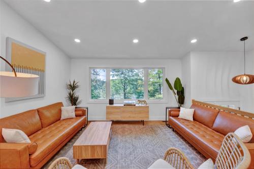 a living room with brown leather couches and a table at Lakeside, Dock, Hot Tub, Kayaks, Arcade, Playset in Lake Ariel