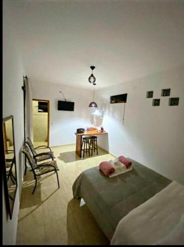 ein Schlafzimmer mit einem Bett, einem Stuhl und einem Tisch in der Unterkunft Hospedaria Porto de Paz 2 in Cunha