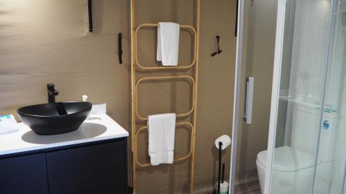 a bathroom with a black sink and a shower at Magnetic Glamping in Nelly Bay
