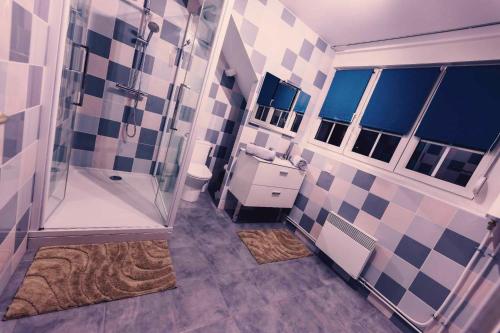 a bathroom with a shower and a tiled wall at love room l'écrin du désir in Aubers