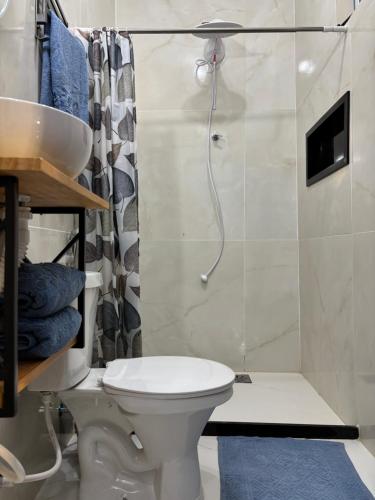 a bathroom with a toilet and a shower at Recanto da Cachoeira RJ in Magé