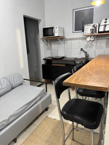 a room with a bed and a table and a desk at Recanto da Cachoeira RJ in Magé