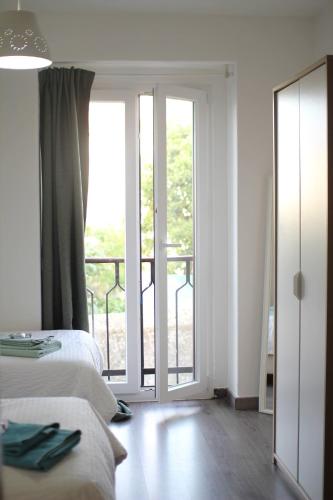 a white room with two beds and a balcony at Vila Mafra - Grill Terrace in Mafra