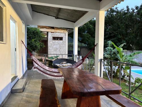 a hammock on the back porch of a house at Recanto da Cachoeira RJ in Magé