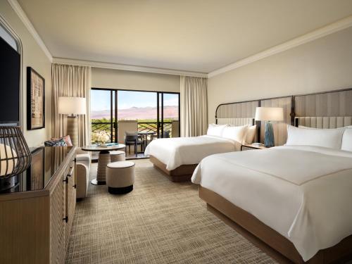 a hotel room with two beds and a balcony at Fairmont Orchid in Waikoloa