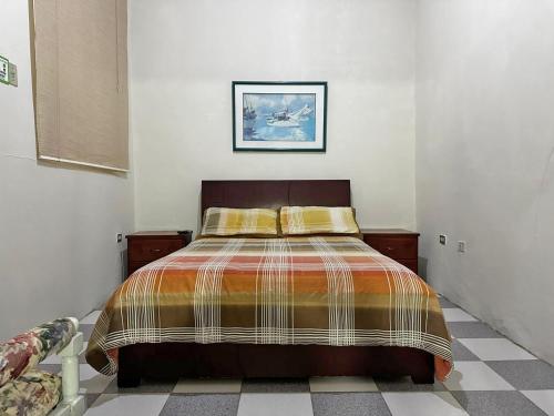 a bedroom with a bed and a picture on the wall at Hostal Latina in Cuenca