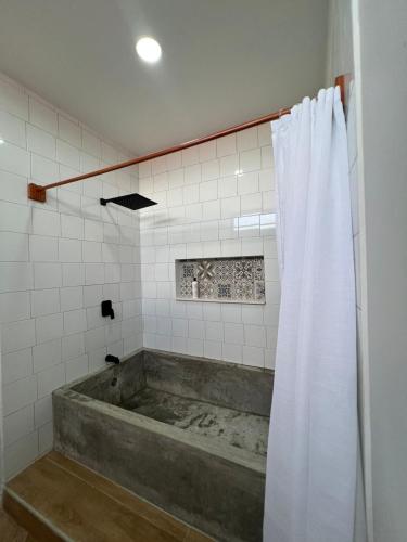 a bath tub with a shower curtain in a bathroom at La Isla Bonita Residence in Flores