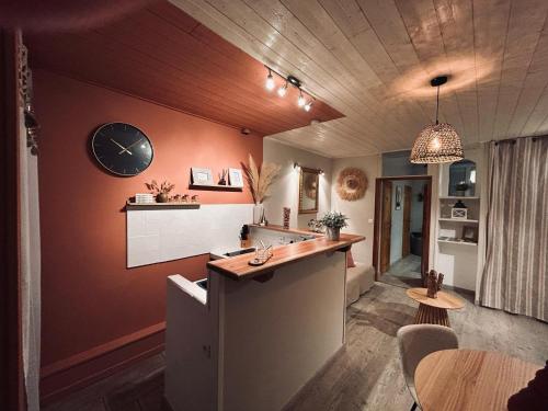 une cuisine avec un comptoir et une horloge au mur dans l'établissement Appartement cévenol chaleureux, à La GrandʼCombe