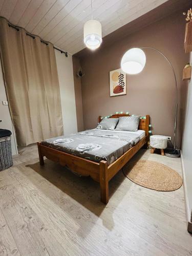 une chambre avec un grand lit dans une pièce dans l'établissement Appartement cévenol chaleureux, à La GrandʼCombe