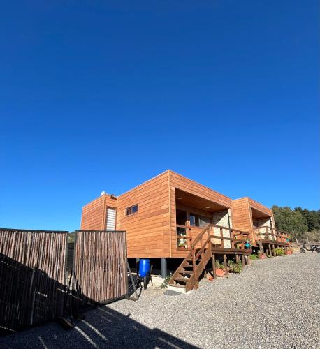 a wooden house with a fence and a bike in front of it at Cabañas Altos de Cahuil in Cáhuil