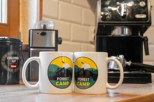 three coffee mugs sitting on a wooden counter at Forest Camp Dom w Górach Sowich in Michałkowa