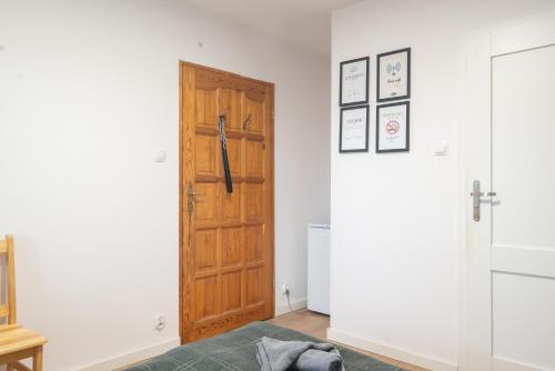 a room with a wooden door and a bed at Studio I Pokoje I Pokoje z łazienkami in Gdańsk