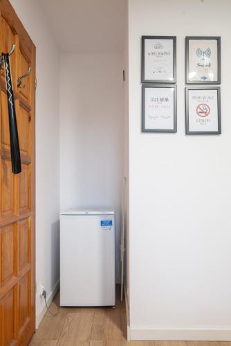a refrigerator in a room next to a door at Studio I Pokoje I Pokoje z łazienkami in Gdańsk