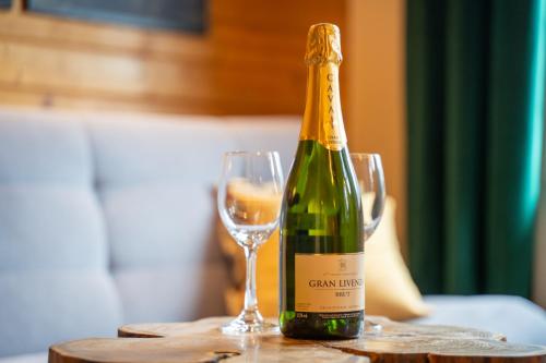 a bottle of champagne and a glass on a table at Forest Camp Dom w Górach Sowich in Michałkowa