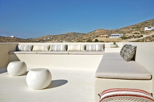 a white boat with pillows and tables on the deck at Agave Donousa Suites in Donoussa