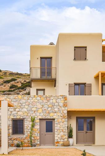 a house with a stone wall at Agave Donousa Suites in Donoussa