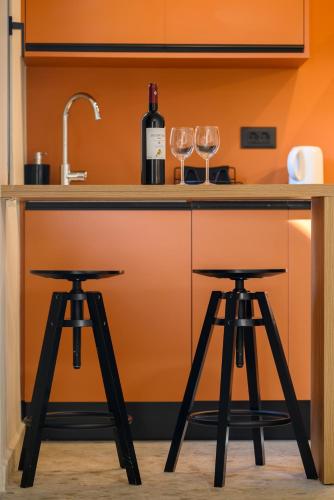 a bar with two wine glasses and two stools at MOD 15 City Centre in Agios Nikolaos