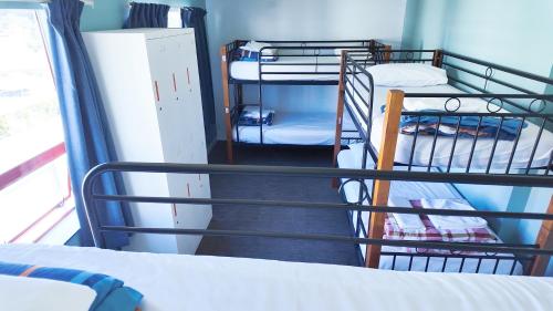 a room with several bunk beds and a staircase at United Auckland in Auckland