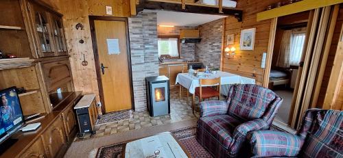 a living room with a table and chairs in a cabin at Chalet with Stunning Lake and Mountain Views avec une vue à couper le souffle, une spacieuse terrasse et jardin in Châtillon