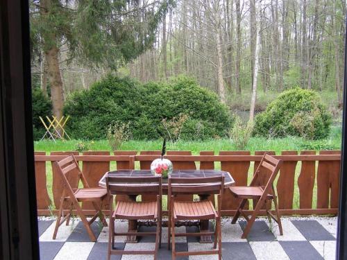 a table with chairs and a vase of flowers on it at Borówkowa Agroturystyka Nad Morzem in Darłowo