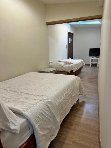 a bedroom with two beds and a piano at Hostal Latina in Cuenca
