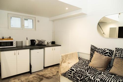 un salon avec un canapé et une cuisine dans l'établissement Studio Stade de France 26 pour 2 personnes, à Saint-Denis