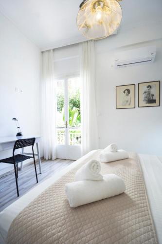 a white bedroom with a bed and a desk at Superior Apartment Near Beach in Chania