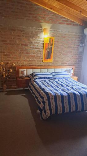 a bed in a room with a brick wall at Departamento Ruca che in Neuquén