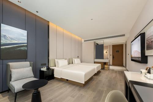 a bedroom with a bed and a desk and a chair at Atour Hotel Foshan Foshan Shunde Fisherman's Wharf in Shunde