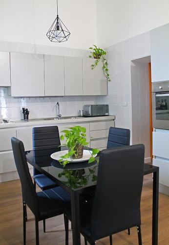 a dining room table with chairs and a kitchen at Residenza Noè in Antica Villa - Suite & Spa in Fisciano