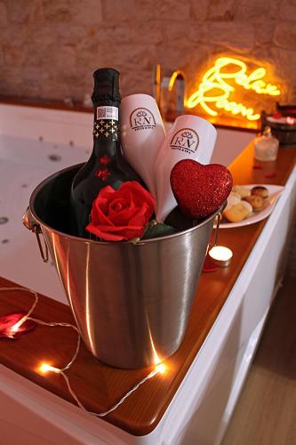 a bucket with a bottle of champagne and roses at Residenza Noè in Antica Villa - Suite & Spa in Fisciano