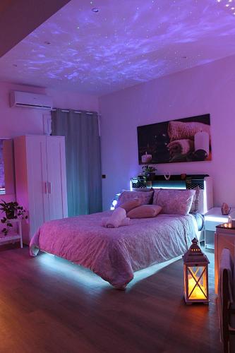 a bedroom with a large bed with purple lighting at Residenza Noè in Antica Villa - Suite & Spa in Fisciano
