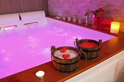 a jacuzzi tub with two baskets filled with sand and hearts at Residenza Noè in Antica Villa - Suite & Spa in Fisciano