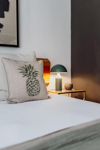 a bed with a pillow with a pineapple on it at Lake Mahinapua Hotel in Ruatapu