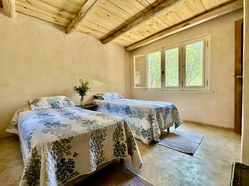 une chambre avec deux lits et une fenêtre dans l'établissement 2 Casas de Campo con bajada exclusiva al Rio Pinto en la Naturaleza, à Cuchi Corral