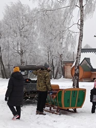 a group of people standing next to a boat in the snow at Chutor Grzegorza in Wysowa-Zdrój
